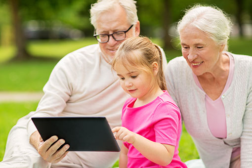 Young girl with grandparents using a tablet